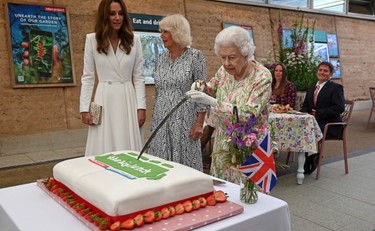 Elizabeth cuts the cake with her sword, and Kate tries to stop it: such irony