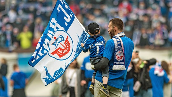 Hansa Rostock's goalkeeper Marcus Kolke celebrates promotion with his son in hand.  © IMAGO / Photo booth 
