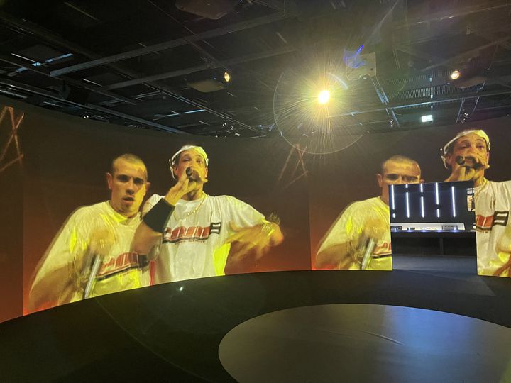 The 360-degree audio-visual space, which immerses the visitor, is at the heart of the exhibition.  All disciplines of hip-hop, including dancers, whose photos are shown in ., navigate through the screens "cypher" (Circle in the middle), for stunning effect.  Here, a live NTM event in Zénith de Paris in 1998. (LAURE NARLIAN / FRANCEINFO)